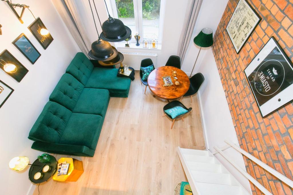 vista sul soffitto di un soggiorno con divano verde di BERG Apartament Green GDANSK a Danzica