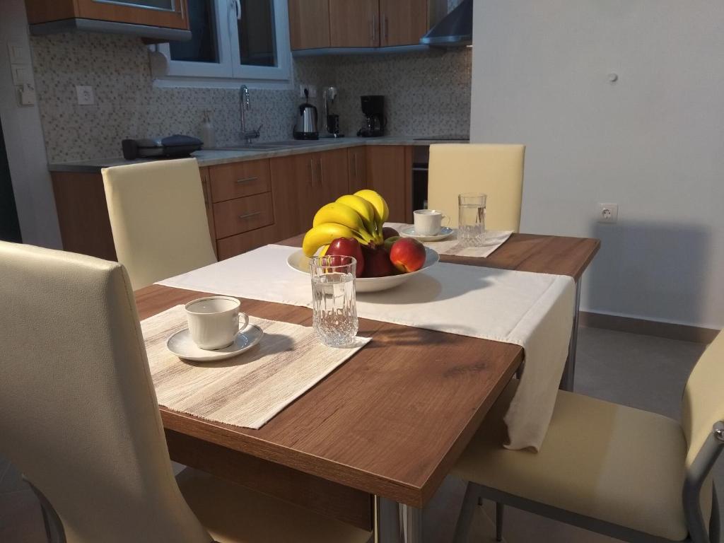 una mesa de madera con un bol de fruta. en Myrina View, en Mirina