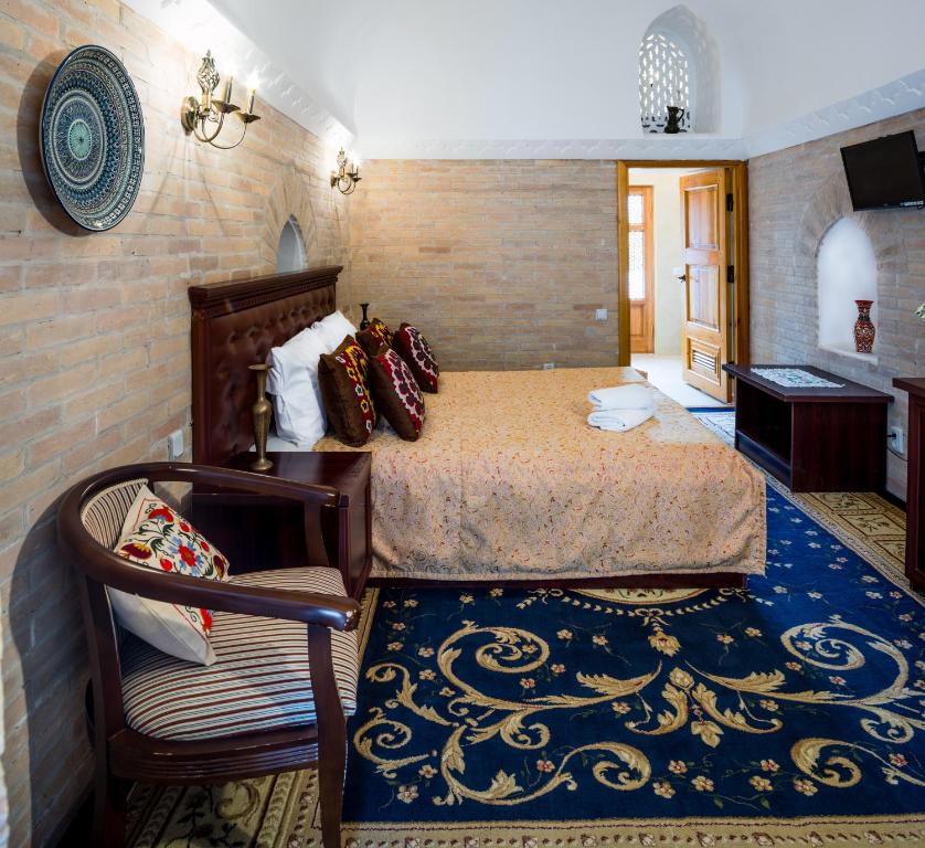Кровать или кровати в номере Orient Star Khiva Hotel- Madrasah Muhammad Aminkhan 1855