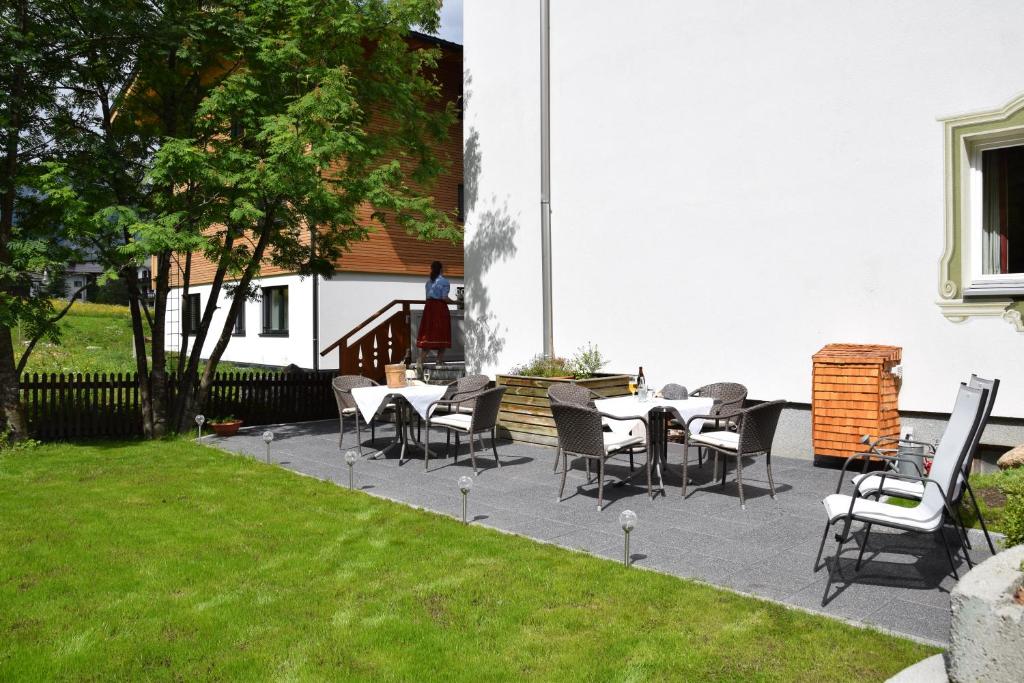 eine Terrasse mit Tischen und Stühlen im Hof in der Unterkunft Hotel - Pension Fortuna in Lech am Arlberg