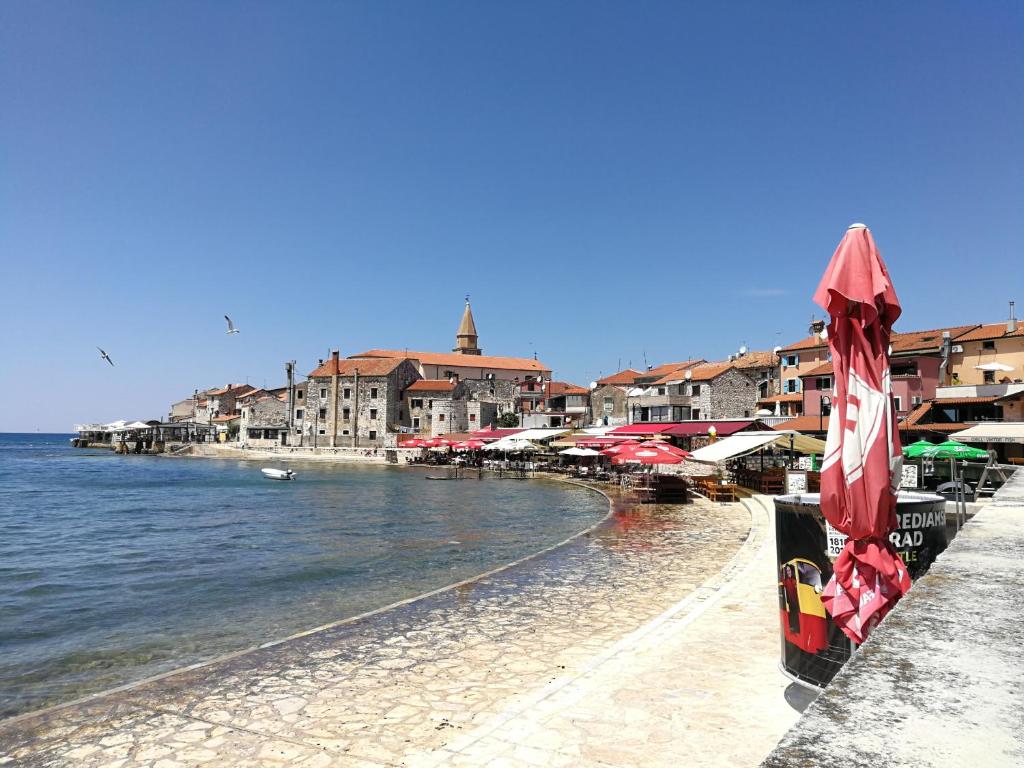 a beach with umbrellas and buildings and the water at Apartment Nika in Umag