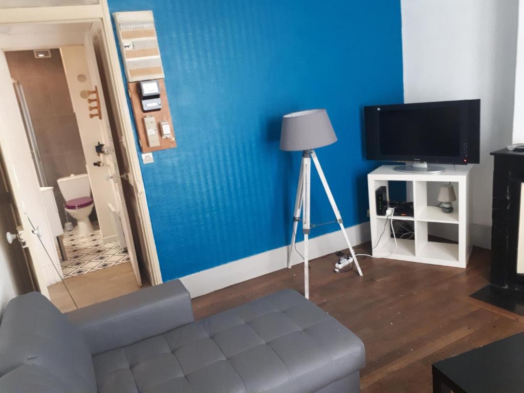 uma sala de estar com uma parede azul e uma televisão em Rent4night Grenoble Aigle em Grenoble