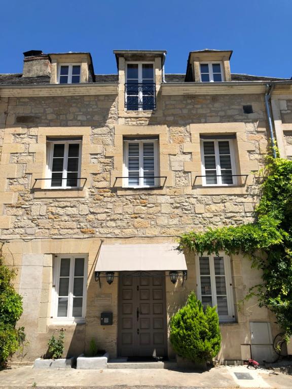 テラソンにあるLes Maisons du Périgordの窓と扉のある古い石造りの建物