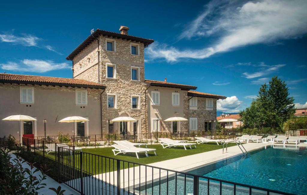 um edifício com piscina em frente a um edifício em Relais Madergnago Gardapartments em Desenzano del Garda