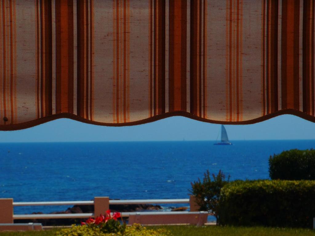 - une vue sur l'océan avec un voilier au loin dans l'établissement studio pieds dans l'eau, à Saint-Raphaël