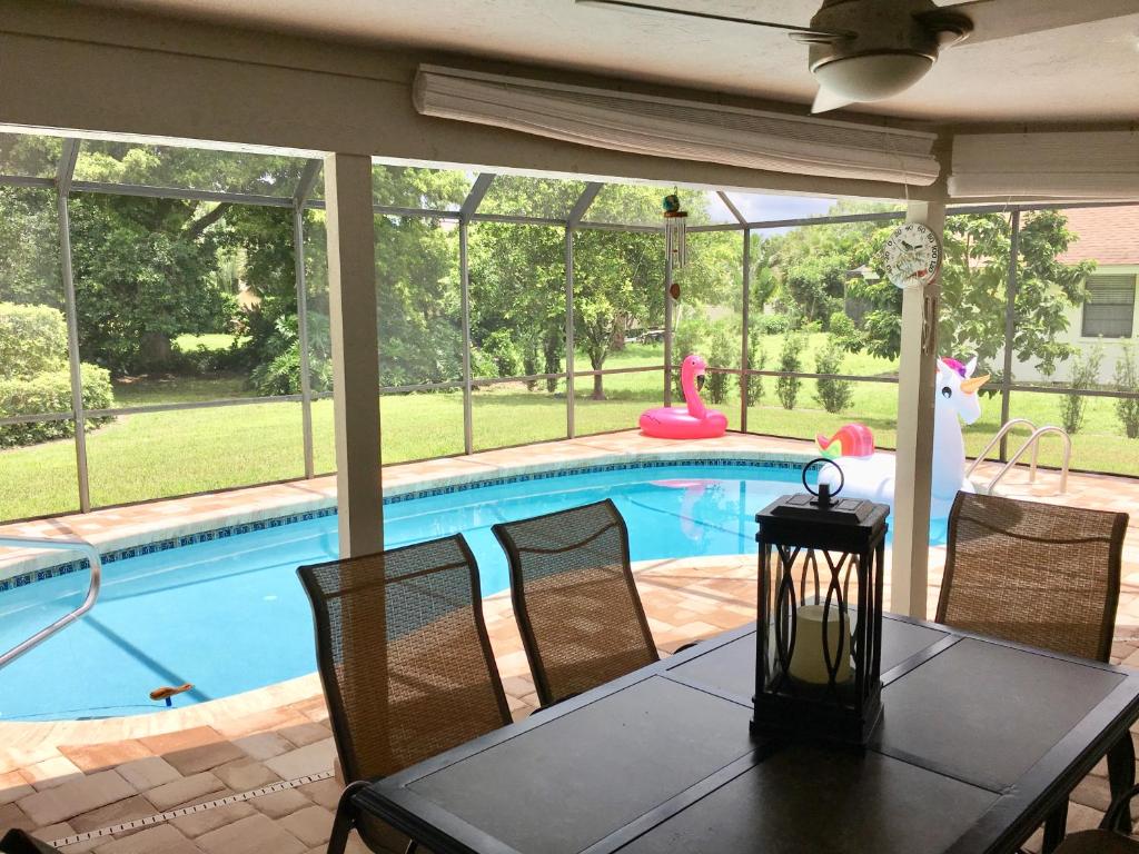 a dining room with a table and a swimming pool at VILLA BELLY in Naples in Naples