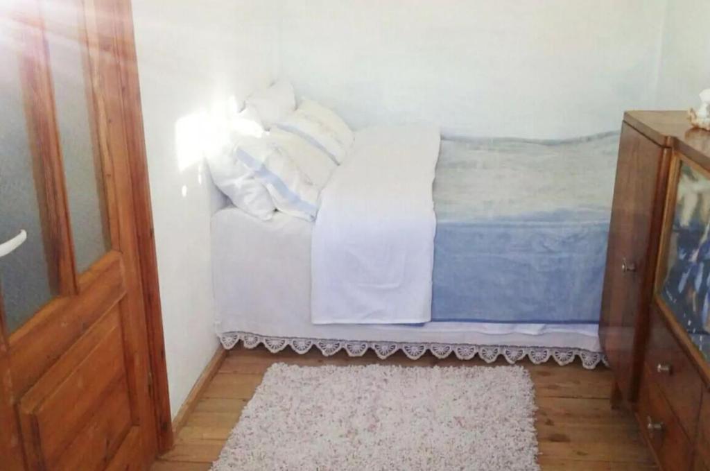 1 dormitorio con cama con almohadas y alfombra en Small room for two in private villa, en Korçë