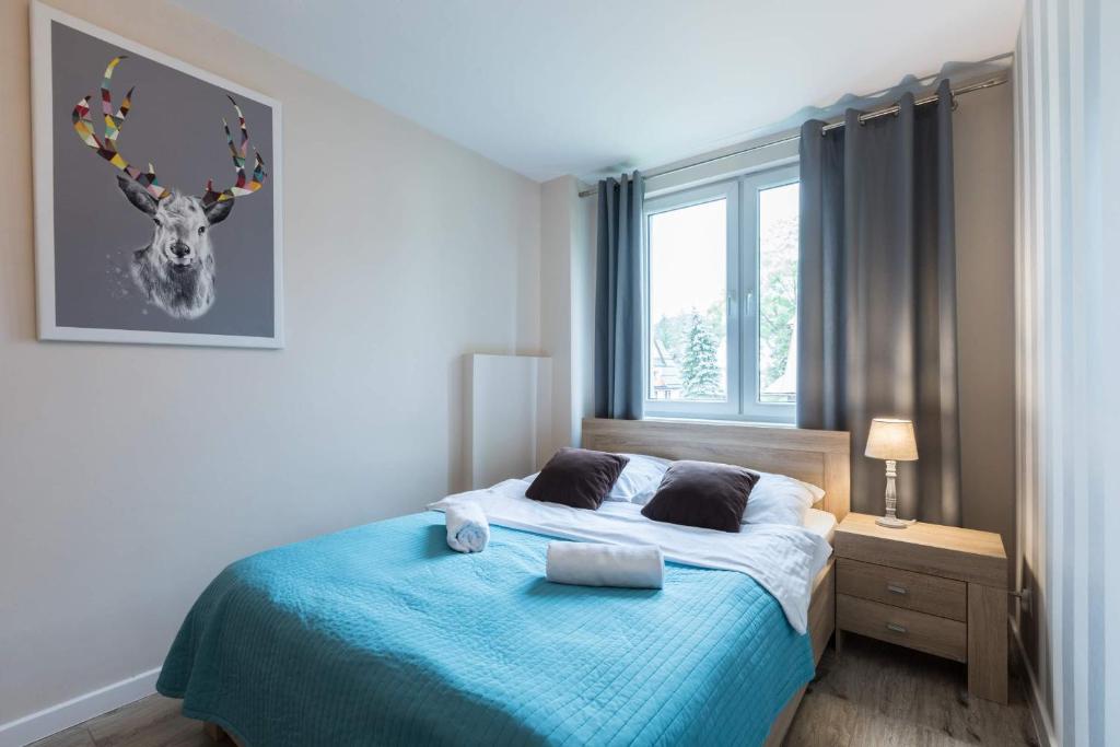 um quarto com uma cama com uma imagem de veado na parede em Apartament Premium Odkryj Zakopane em Zakopane