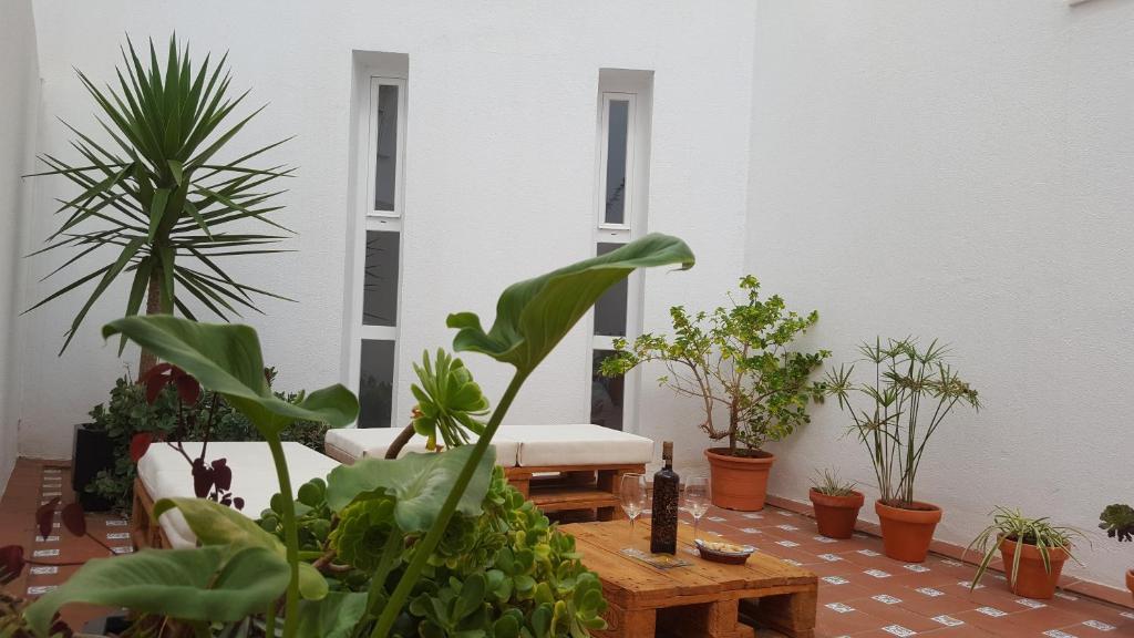 サン・フェルナンドにあるApartamentos Coralba - Dúplex Bahía de Cádizのたくさんの植物とテーブルが並ぶ部屋