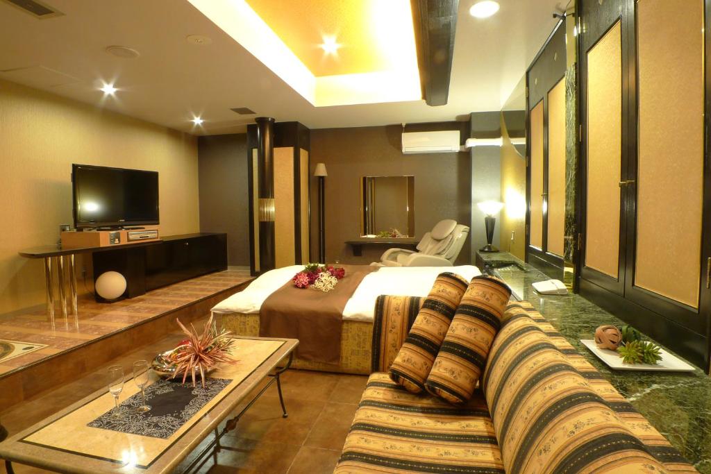 een hotelkamer met een bed en een bank bij Hotel Mermaid (Adult Only) in Miura