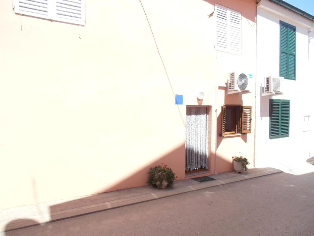 un bâtiment blanc avec deux plantes en pot devant lui dans l'établissement Studio apartment Lucija, à Privlaka