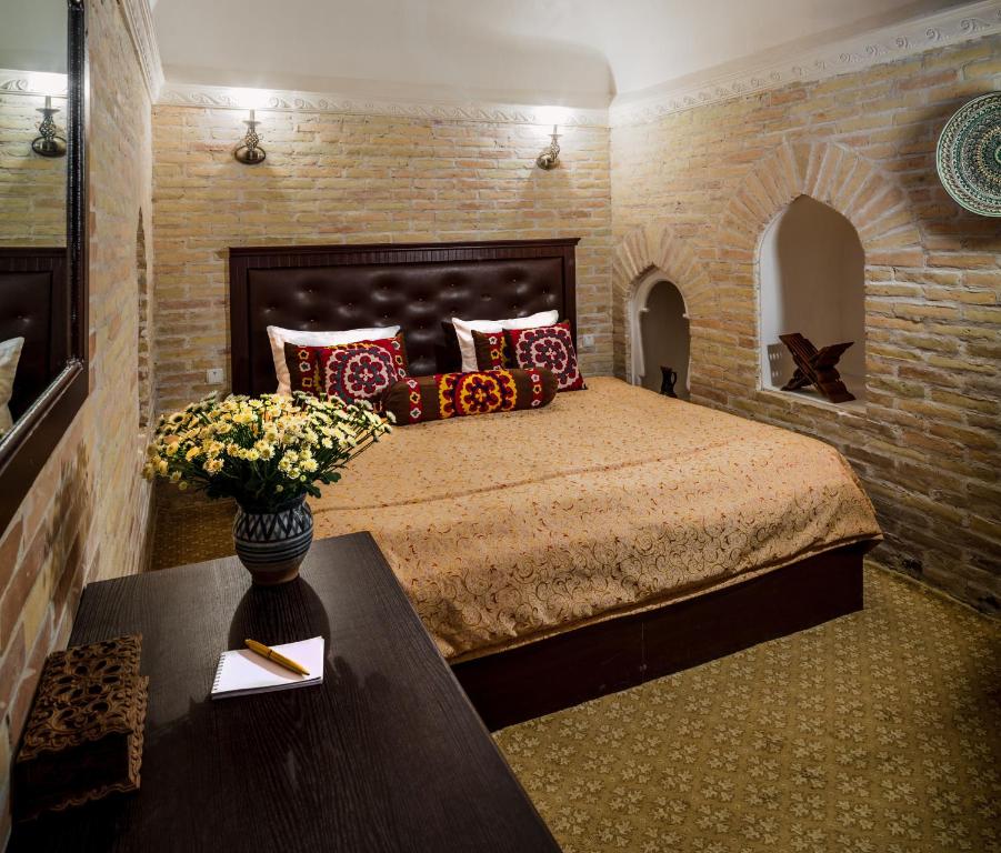 Кровать или кровати в номере Orient Star Khiva Hotel- Madrasah Muhammad Aminkhan 1855