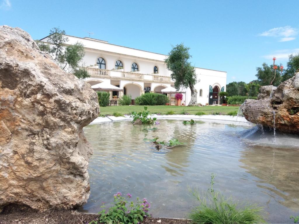 a large building with a pond in front of it at Masseria Montevergine in Otranto