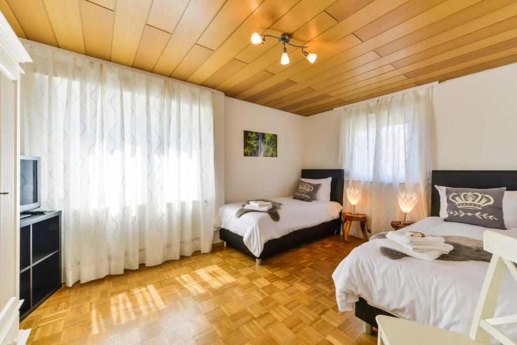 a bedroom with two beds and a window with curtains at Ferienhaus Vier Jahreszeiten in Bad Urach
