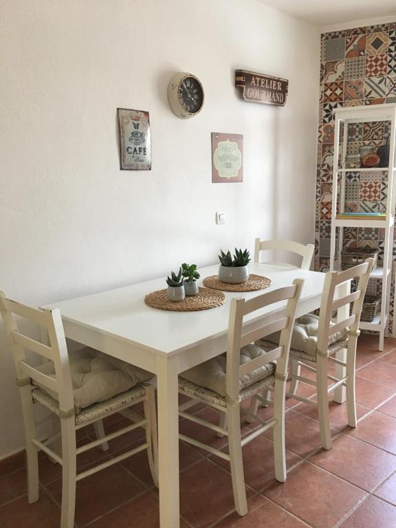 a dining room table with chairs and a white table at Apartamento Turístico Catherine in Trujillo