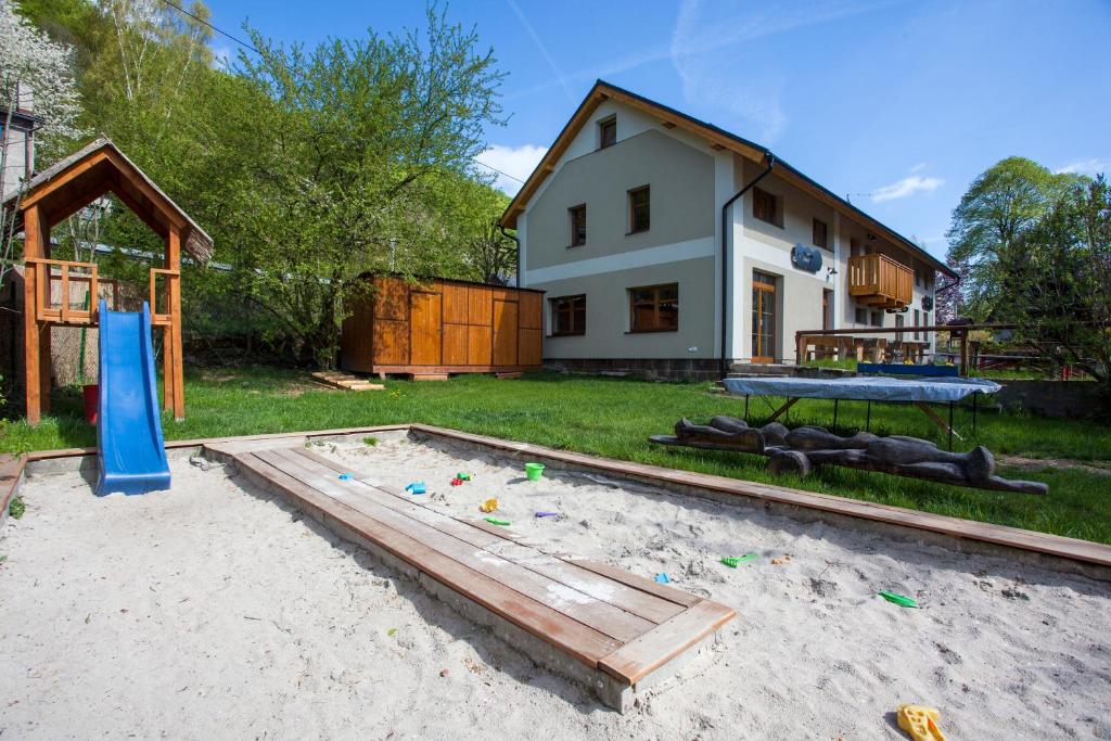 a backyard with a picnic table and a playground at Penzion Krizky in Malá Skála