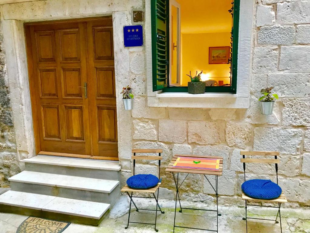 two chairs and a table in front of a door at Sibenik old city studio in Šibenik