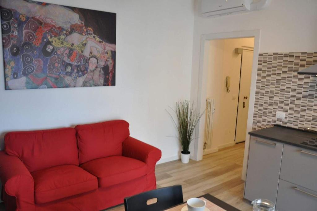 Il comprend un salon avec un canapé rouge et une cuisine. dans l'établissement Milano Easy, à San Donato Milanese