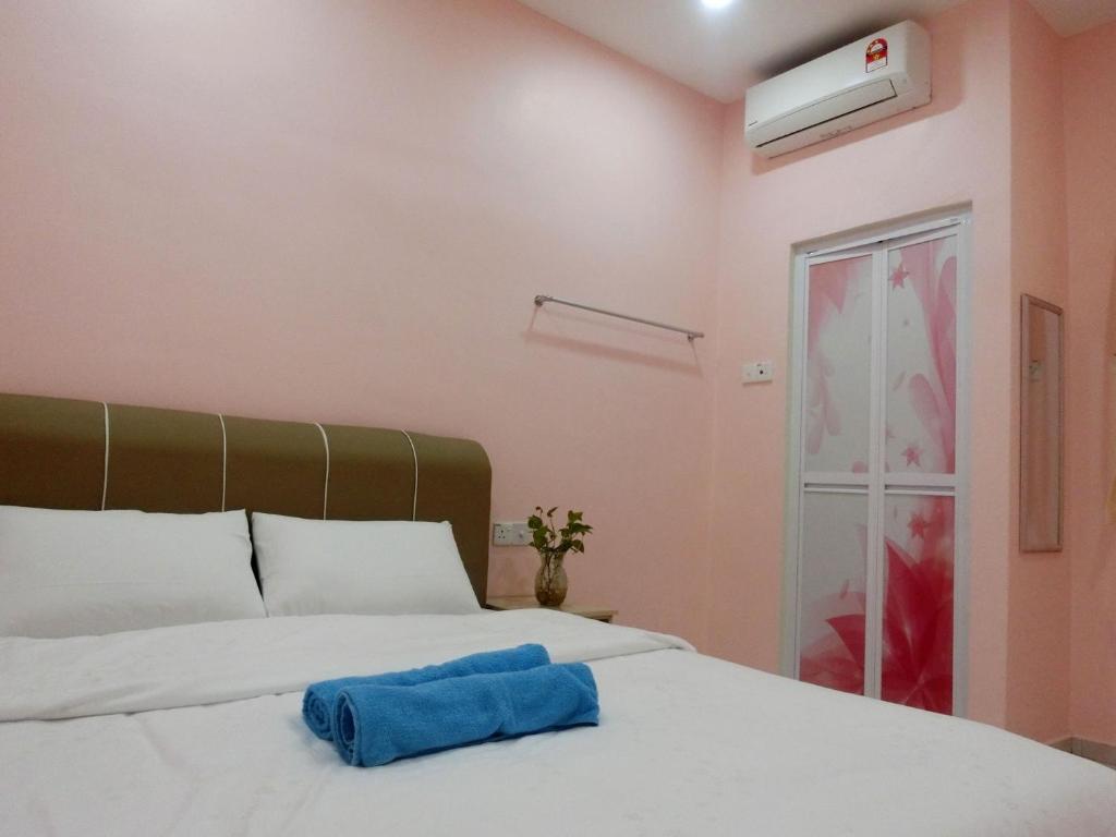 a bedroom with a bed with a blue towel on it at Taiping Cozy Homestay II in Taiping