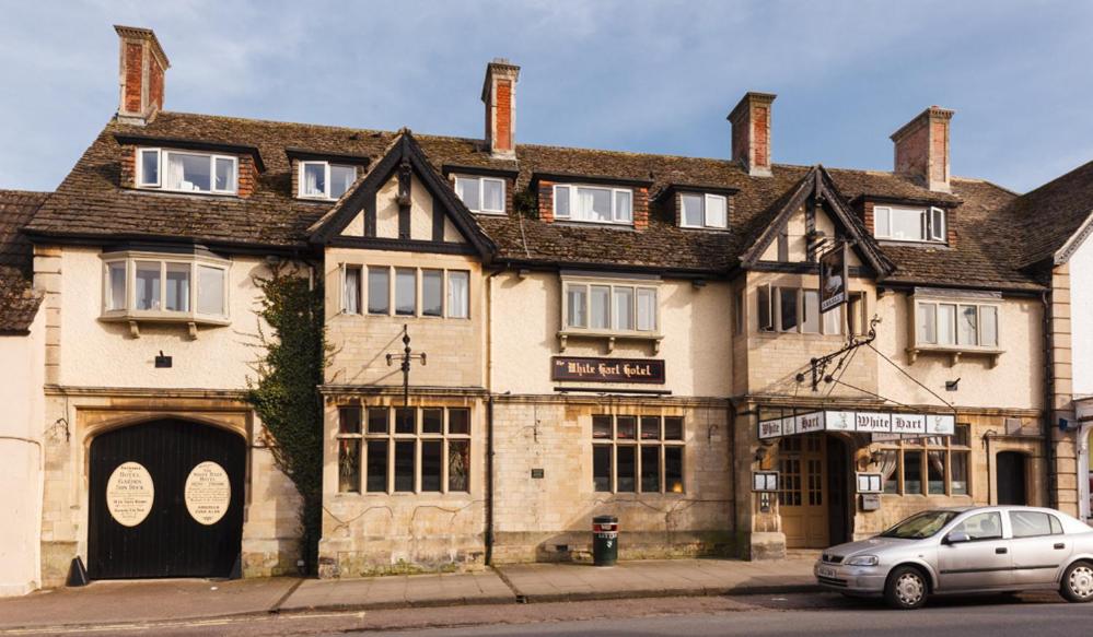 a building with a car parked in front of it at White Hart Hotel in Cricklade