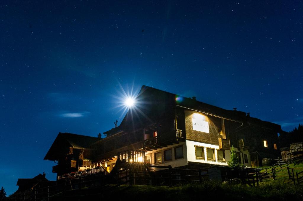 a house with a light on the roof at night at Sattleggers Alpenhof & Feriensternwarte in Berg im Drautal