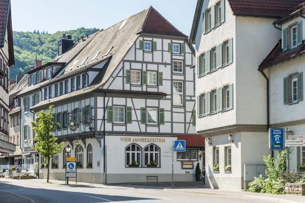 ein weißes und schwarzes Gebäude in einer Stadtstraße in der Unterkunft Flair Hotel Vier Jahreszeiten in Bad Urach