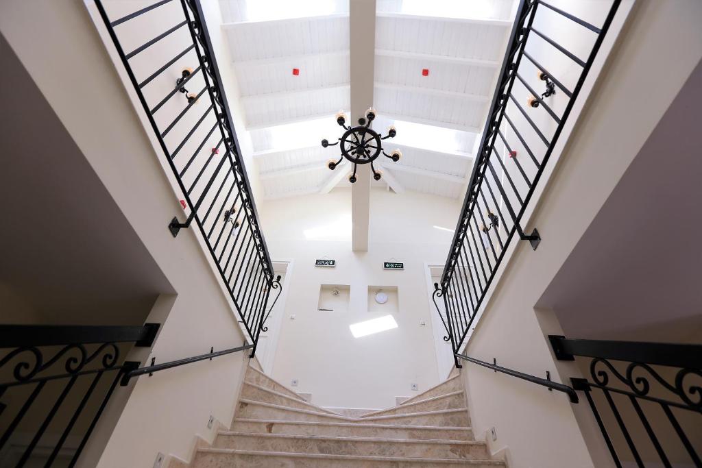 a staircase in a building with a chandelier at Grand Alaçatı Butik Hotel in Alaçatı