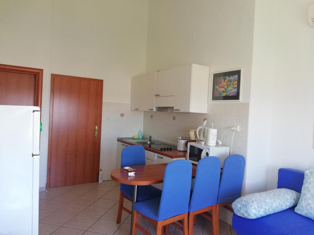 cocina con mesa y sillas azules en una habitación en Apartmani Marija, en Primošten