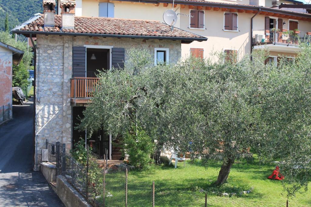 una pequeña casa con un árbol delante en Casa Andreina, en Toscolano Maderno