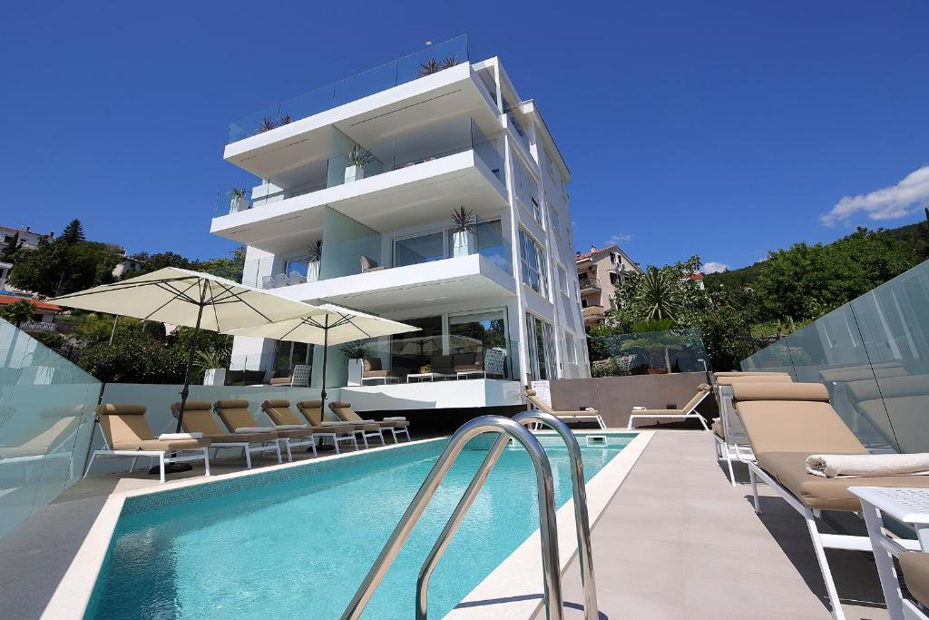 a building with a swimming pool next to a building at Designed Apartment with swimming pool near the beach in Opatija