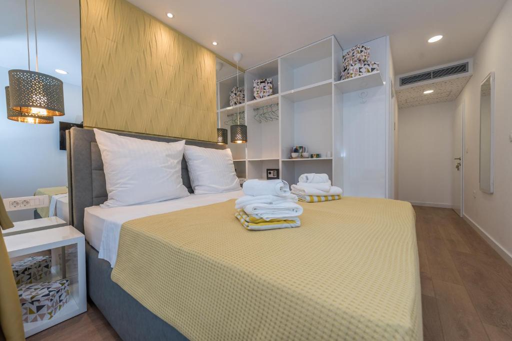 a bedroom with a large bed with towels on it at Gallery Rooms with Parking in Zadar
