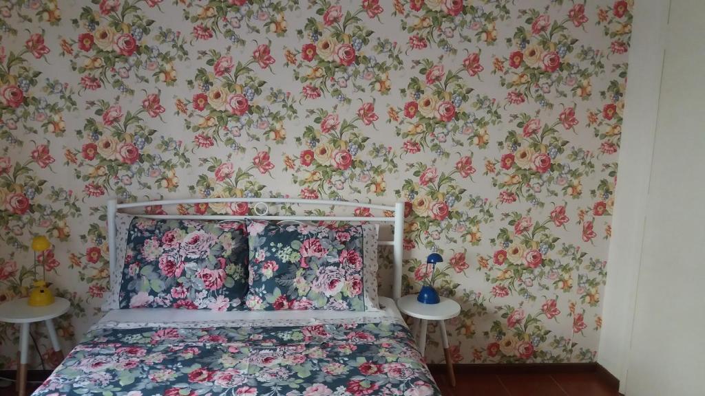 a bedroom with a bed with floral wallpaper at Floral Tribute Studio in Kavála