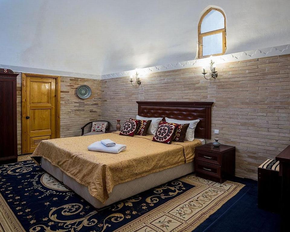 Кровать или кровати в номере Orient Star Khiva Hotel- Madrasah Muhammad Aminkhan 1855