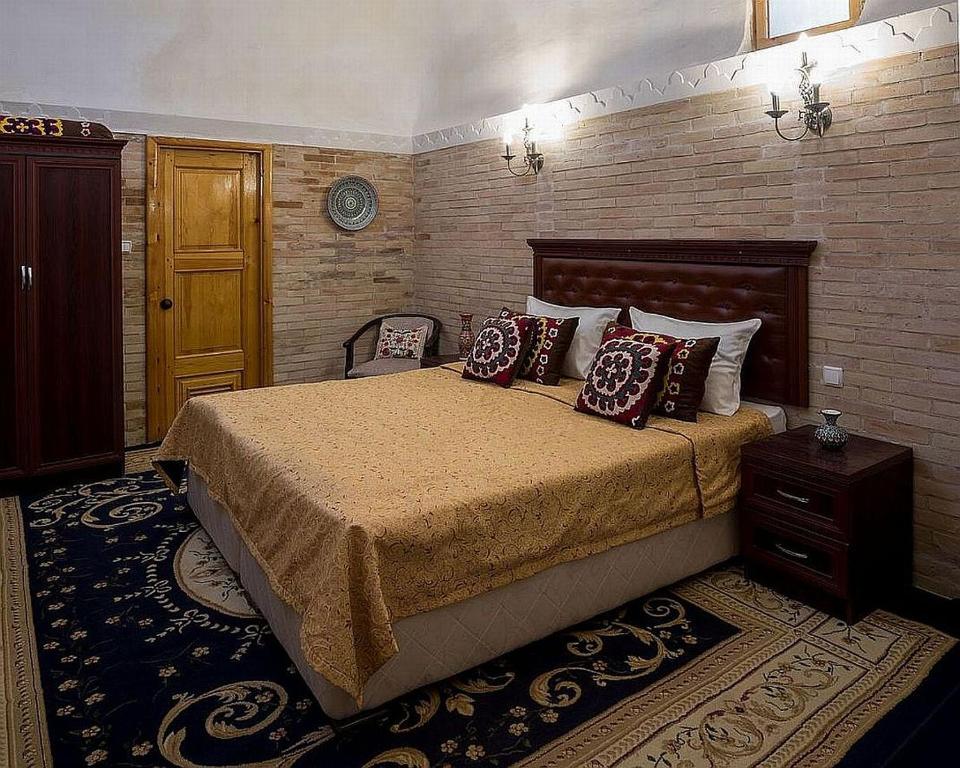 Кровать или кровати в номере Orient Star Khiva Hotel- Madrasah Muhammad Aminkhan 1855