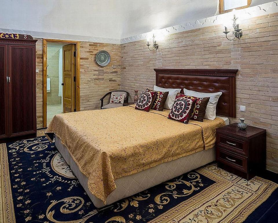 Кровать или кровати в номере Orient Star Khiva Hotel- Madrasah Muhammad Aminkhan 1855