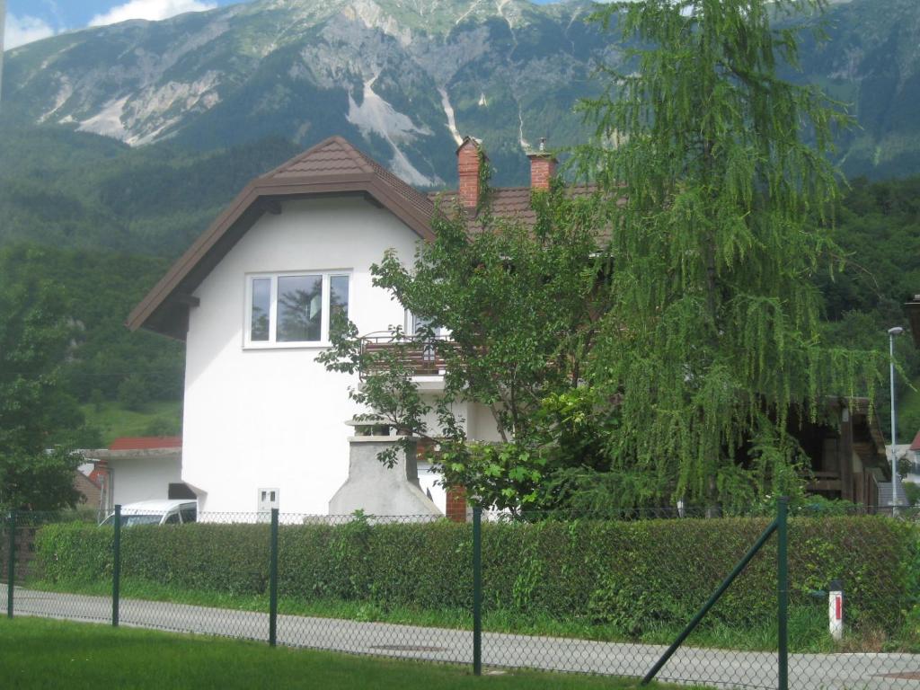 a white house with a mountain in the background at R&G APARTMENT in Žirovnica