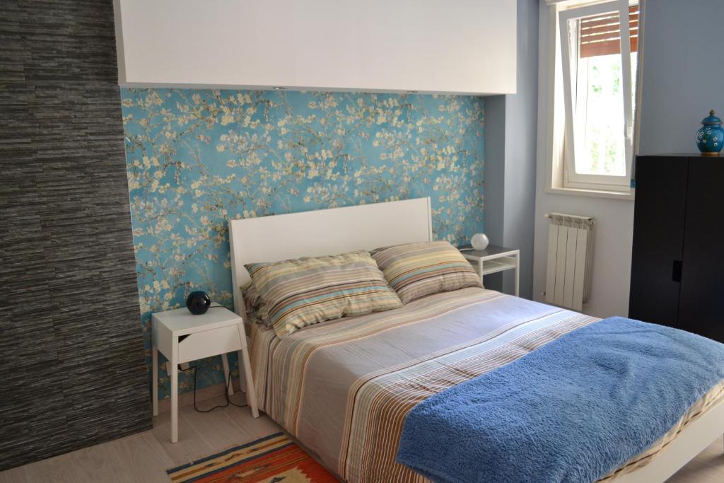 a bedroom with a bed with a blue wall at Suite time Van Gogh in Catania