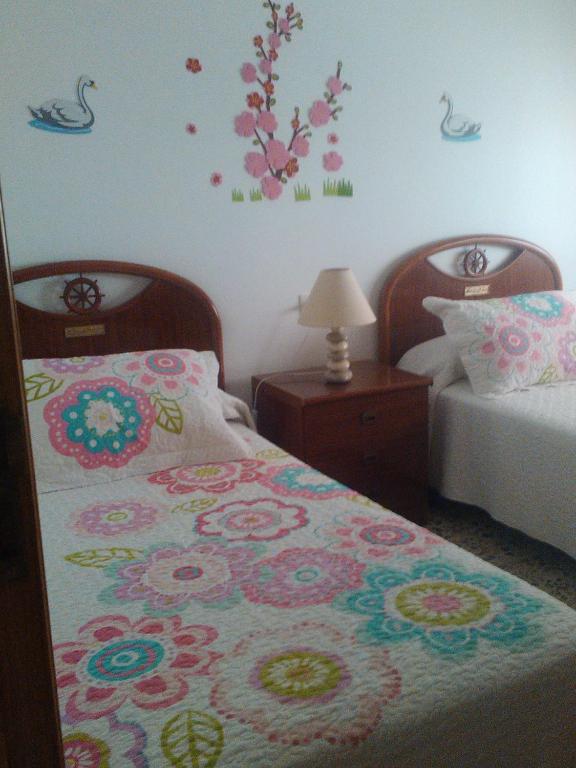 a bedroom with two beds with flowers on the wall at Juami in Portonovo