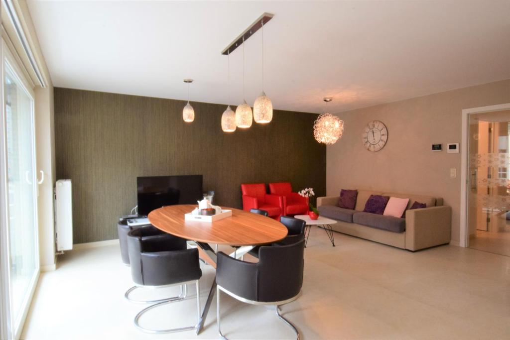 a living room with a table and chairs and a couch at ABC Apartment Langestraat in Blankenberge
