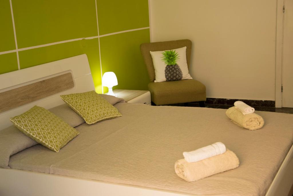 a bedroom with a bed with two towels and a chair at B&B Myrta Maria in Cagliari