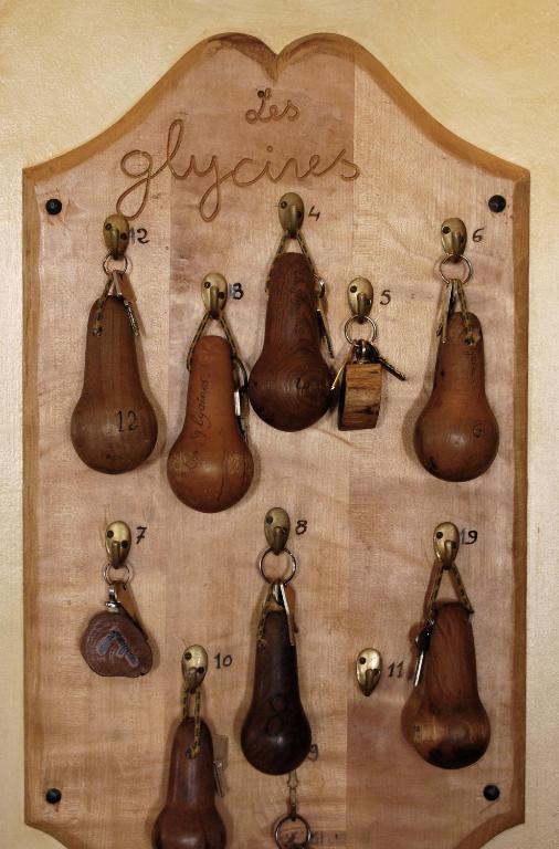 a display of antique bells on a wall at Auberge des Glycines in Porquerolles
