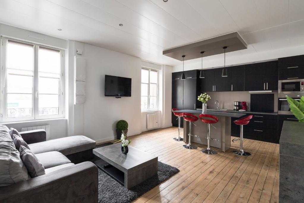 a living room with a couch and a kitchen at Zen et design, proche Cité Corsaire in Saint Malo