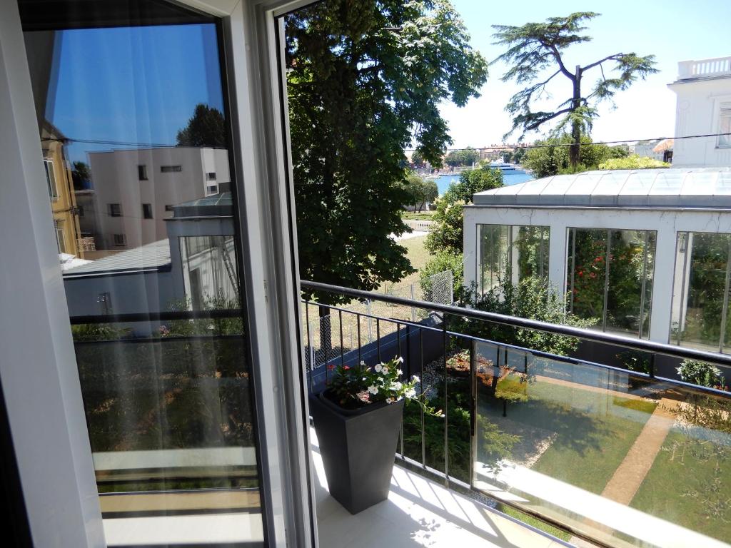 een balkon met uitzicht op een tuin bij Apartman Nia in Zadar