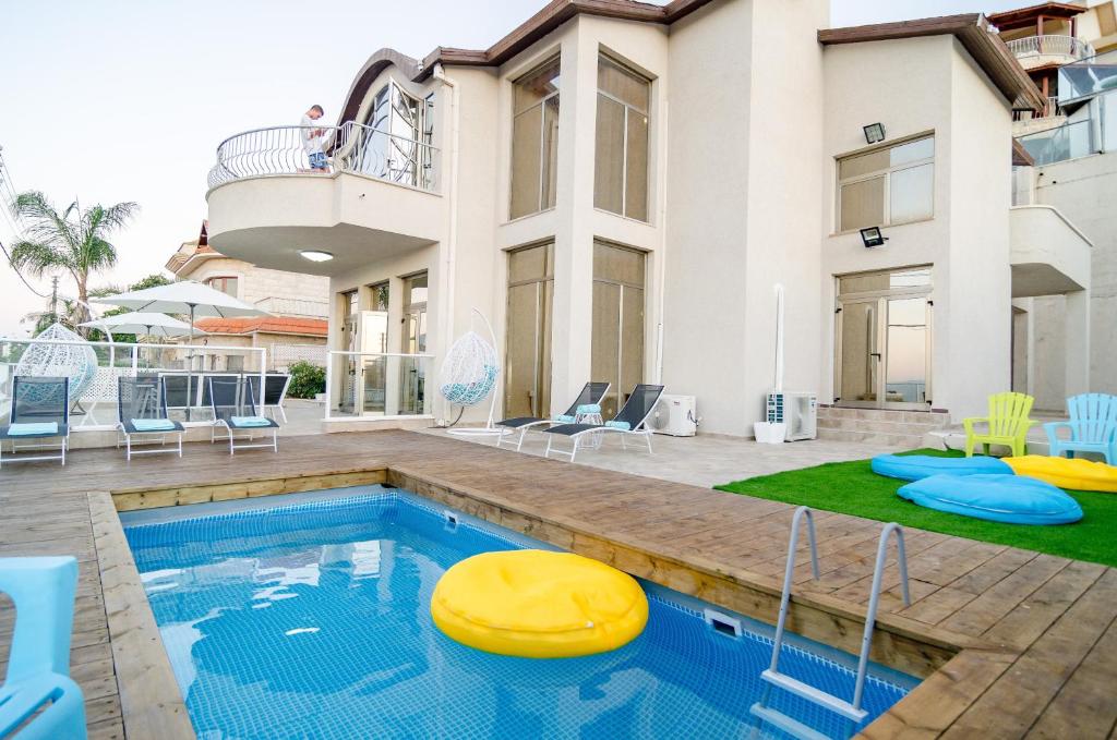 a house with a swimming pool with a yellow frisbee at Blue Sky Villa view in Tiberias