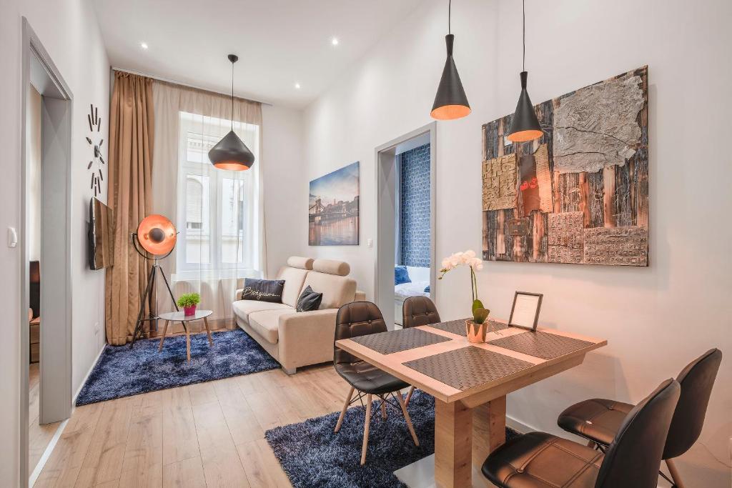 sala de estar con mesa, sillas y sofá en Budapest Broadway Apartment, en Budapest