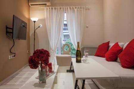 a living room with a bed and a table with flowers at Modern Central Apartment in Thessaloniki