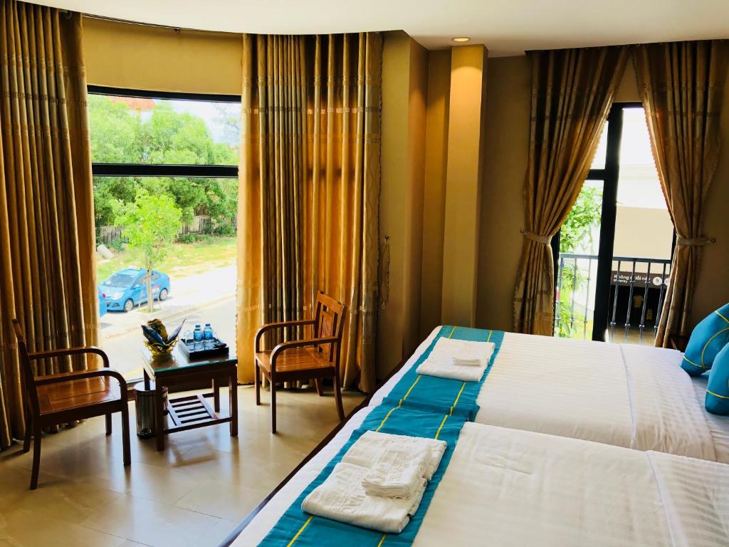 a bedroom with a large bed and a large window at Hồng Hạc Hotel in Tuy Hoa