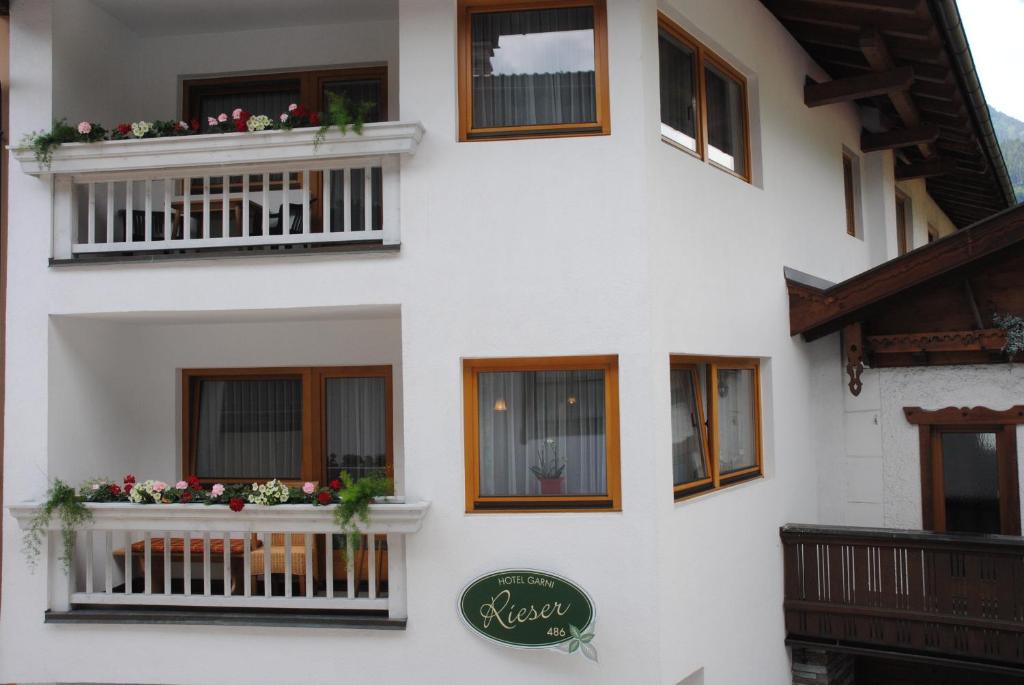 a white building with windows and flowers on the balconies at Gästehaus Rieser in Mayrhofen