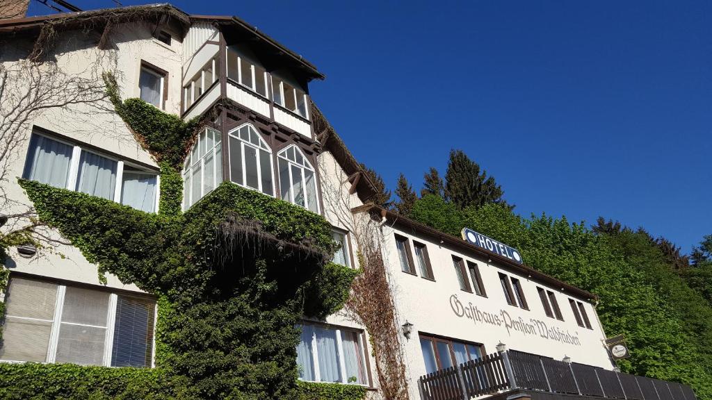 a building with ivy growing on the side of it at Pension Waldfrieden in Wolkenstein