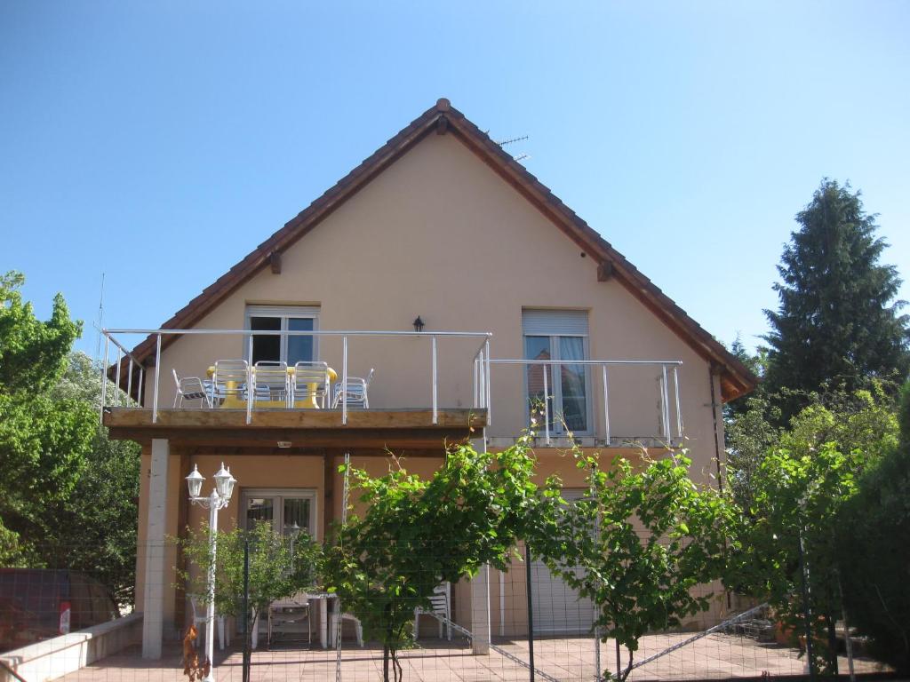 una casa con balcone e sedie di 3A RUE JEAN BAPTISTE WENDLING a Ribeauvillé